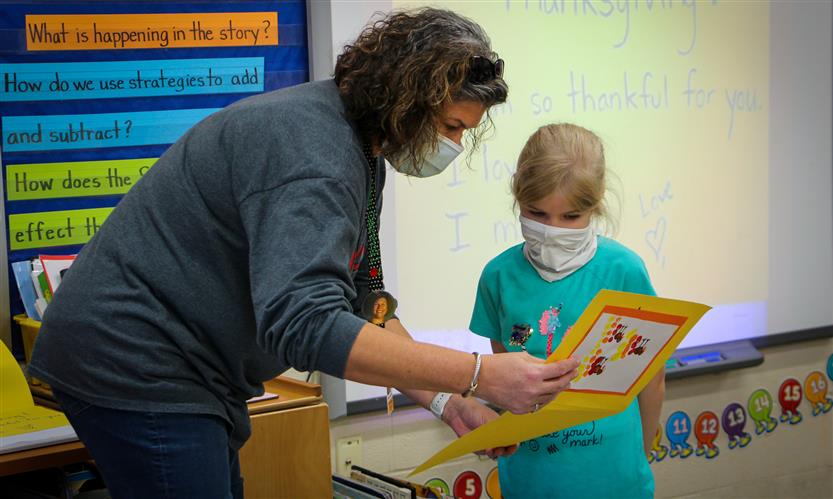 Teacher helps student make thank you card